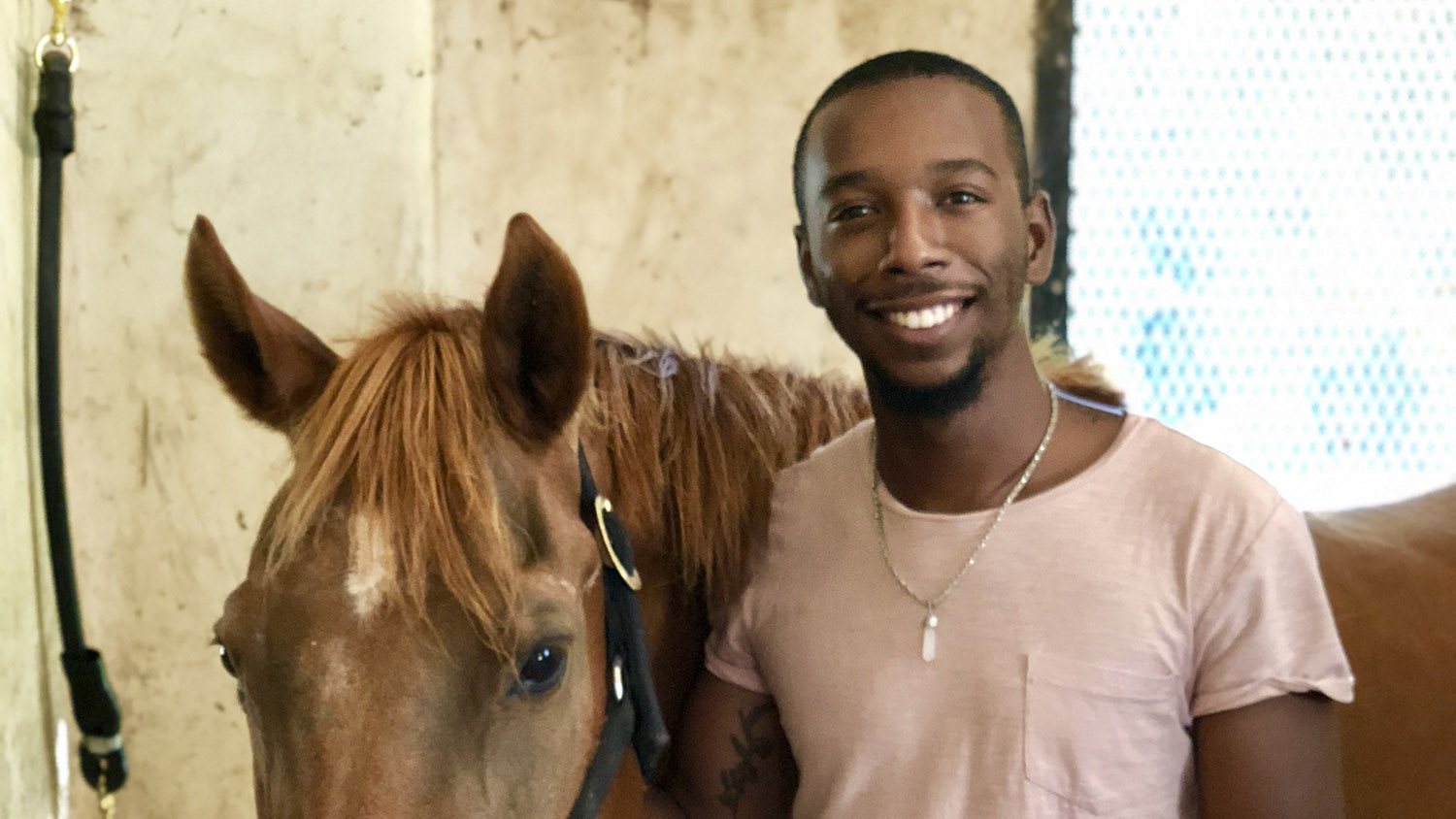 CALS Animal Science alumnus James Quick stands next to a horse.