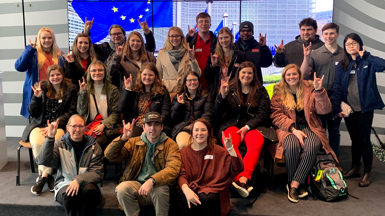 group of students doing a wolfpack sign with their hands