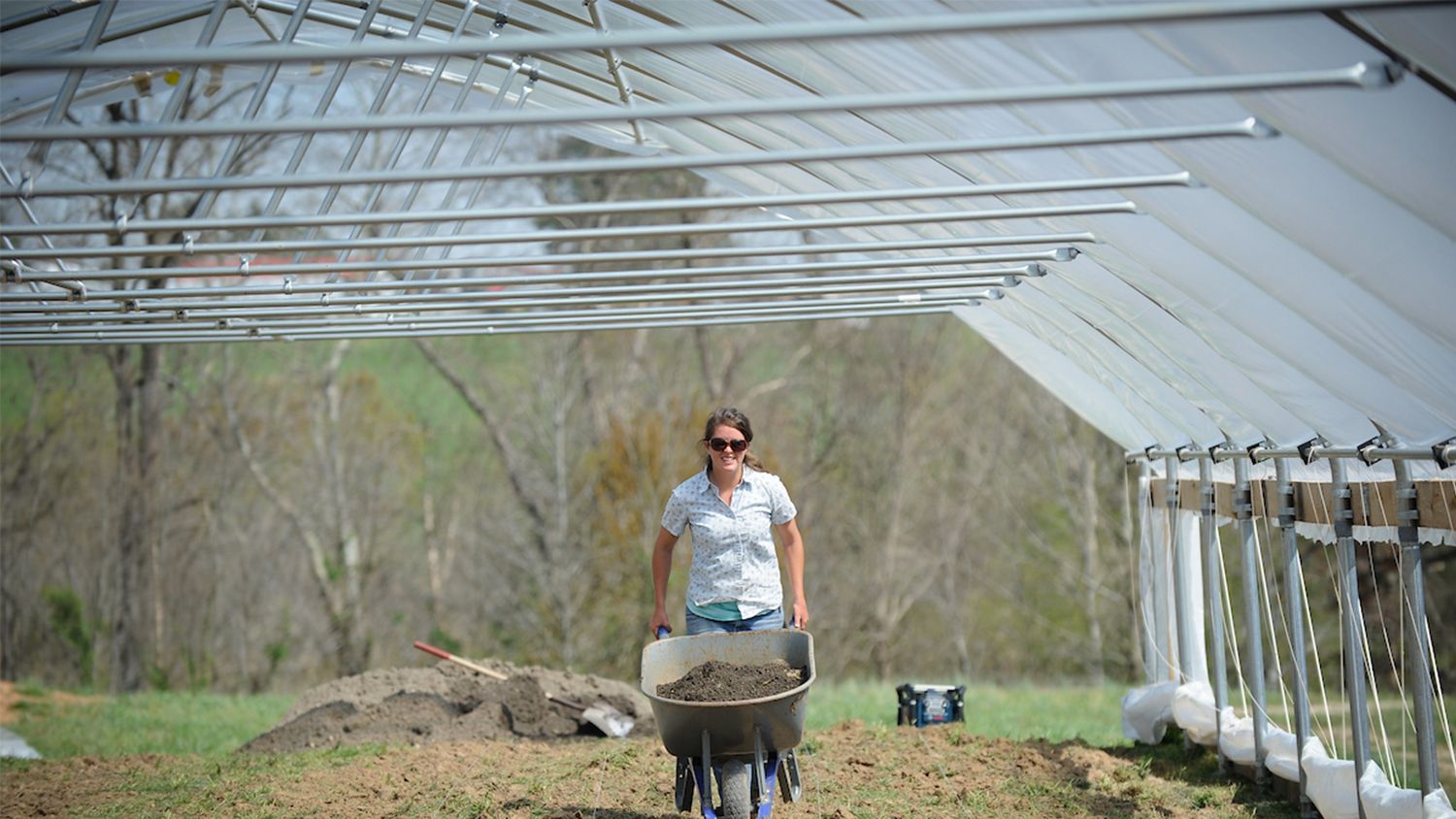 A woman pushing a wheelbarrow threw