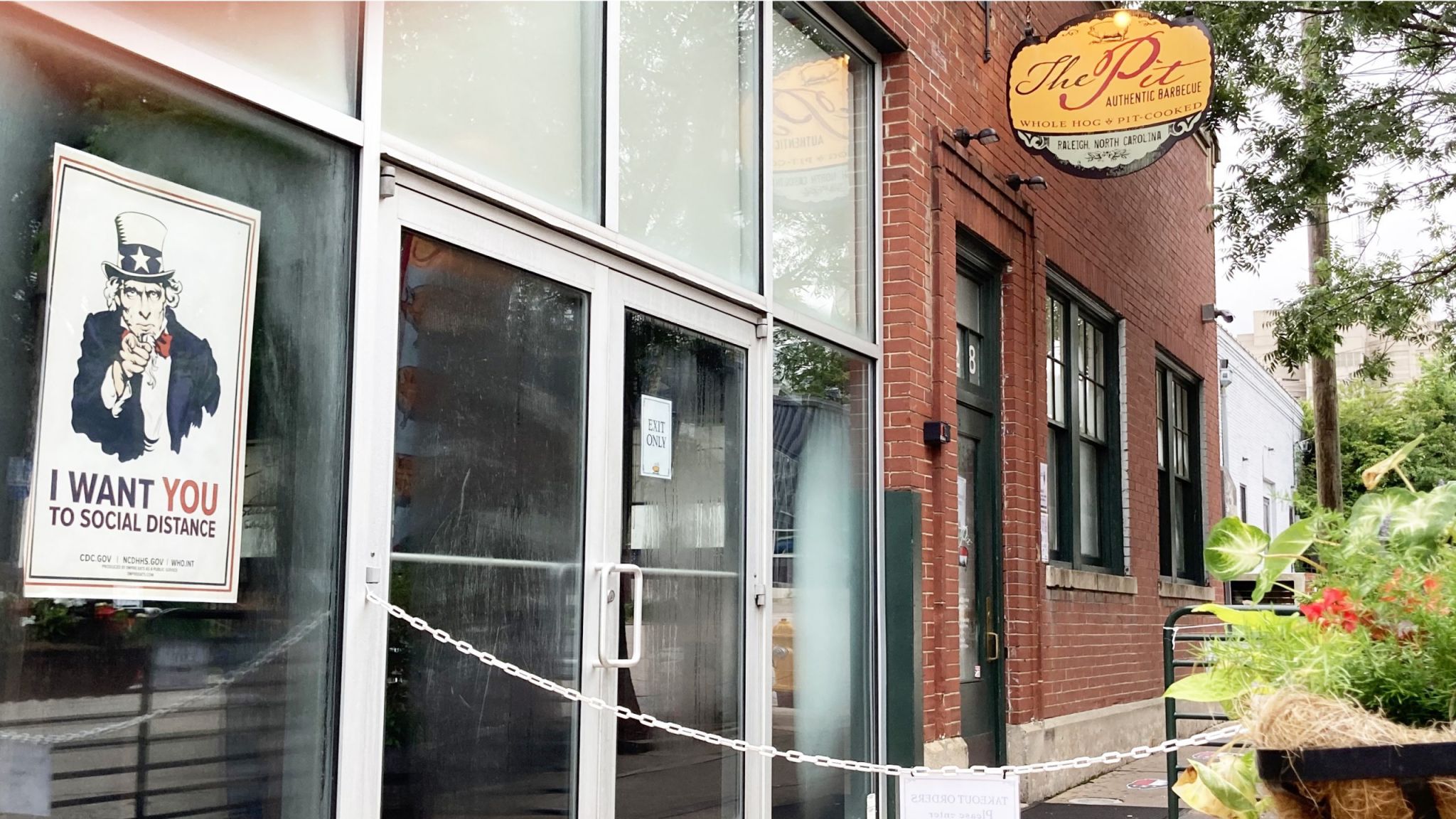 A poster in a window at The Pit restaurant features a pointing Uncle Sam with the slogan, "I want you to social distance."