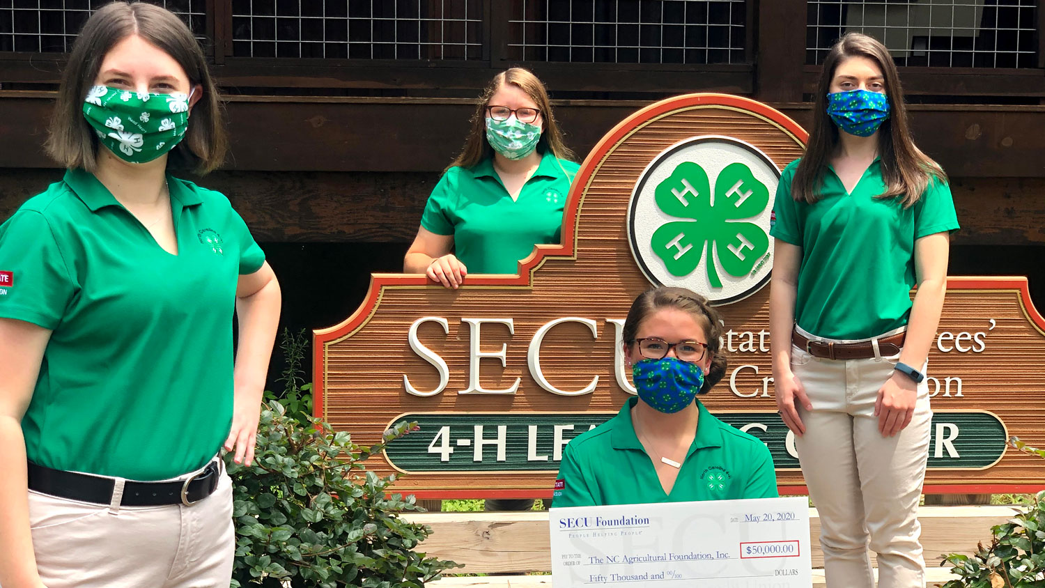 Group of 4-H staff members holding a check from SECU Foundation for $50,000