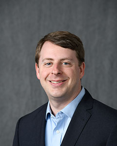 Geoff Bock in front of neutral background.