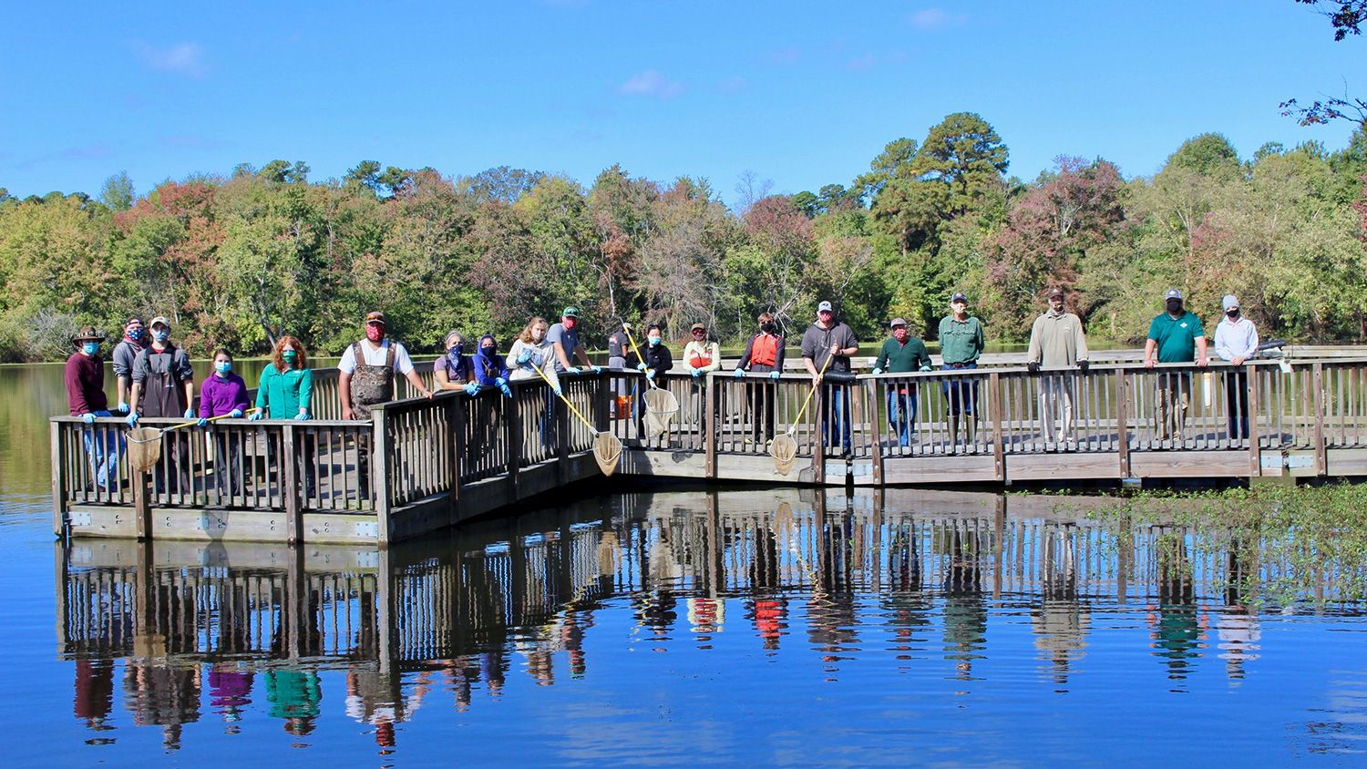 At Lake Raleigh, students stand on a dock after a day of collecting data about fish populations.