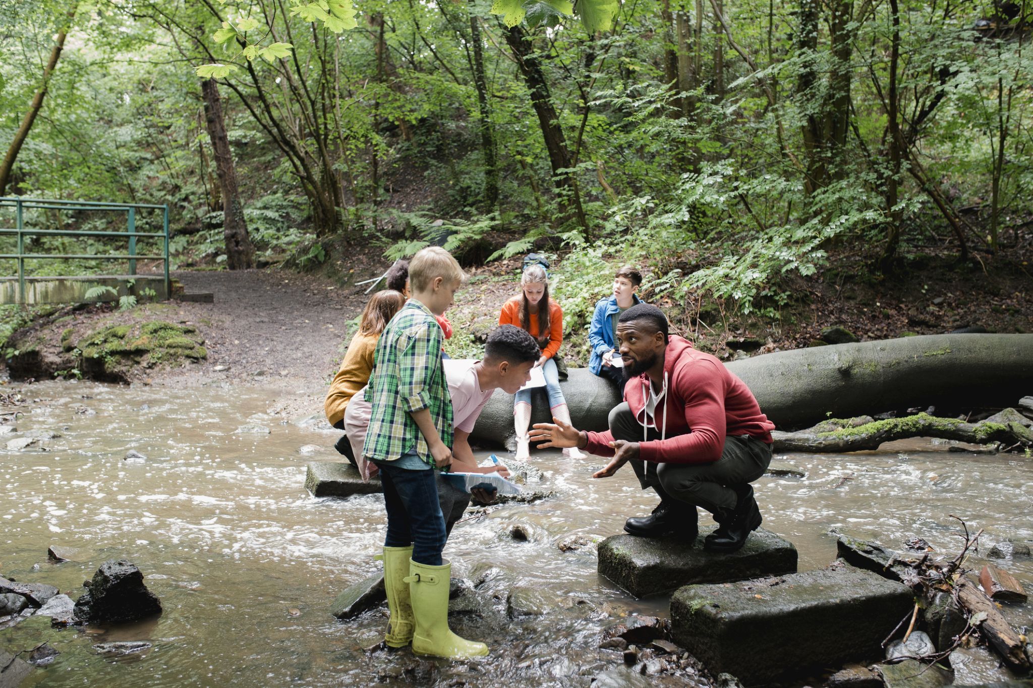 Students learning from teach in a creek