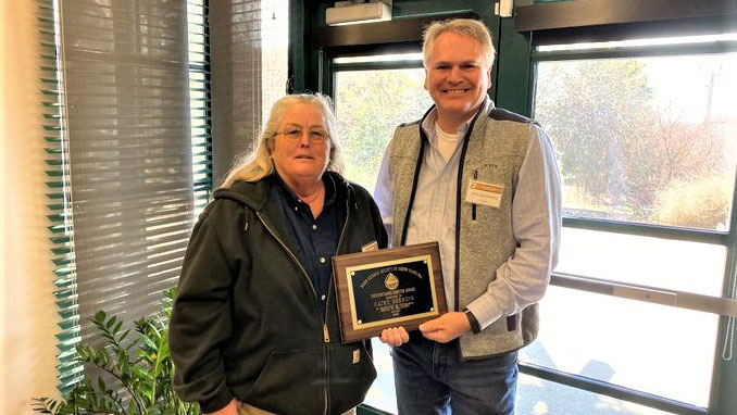 Cathy Herring stands next to Rick Seagroves as she receives the Distinguished Service Award from the Weed Science Society of North Carolina.