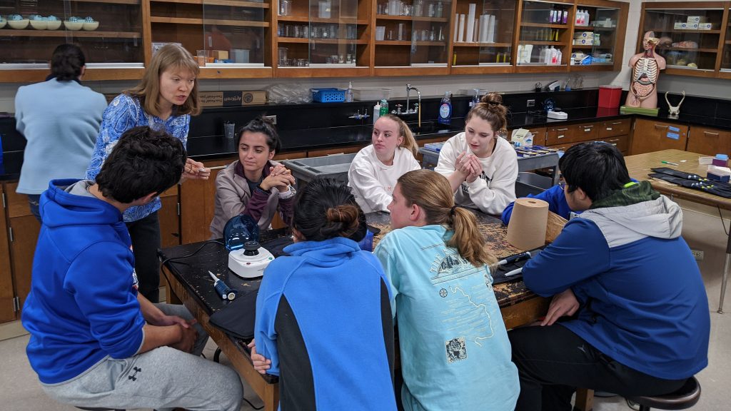 Anna Stepanova, left, speaks to a group of students in the lab.