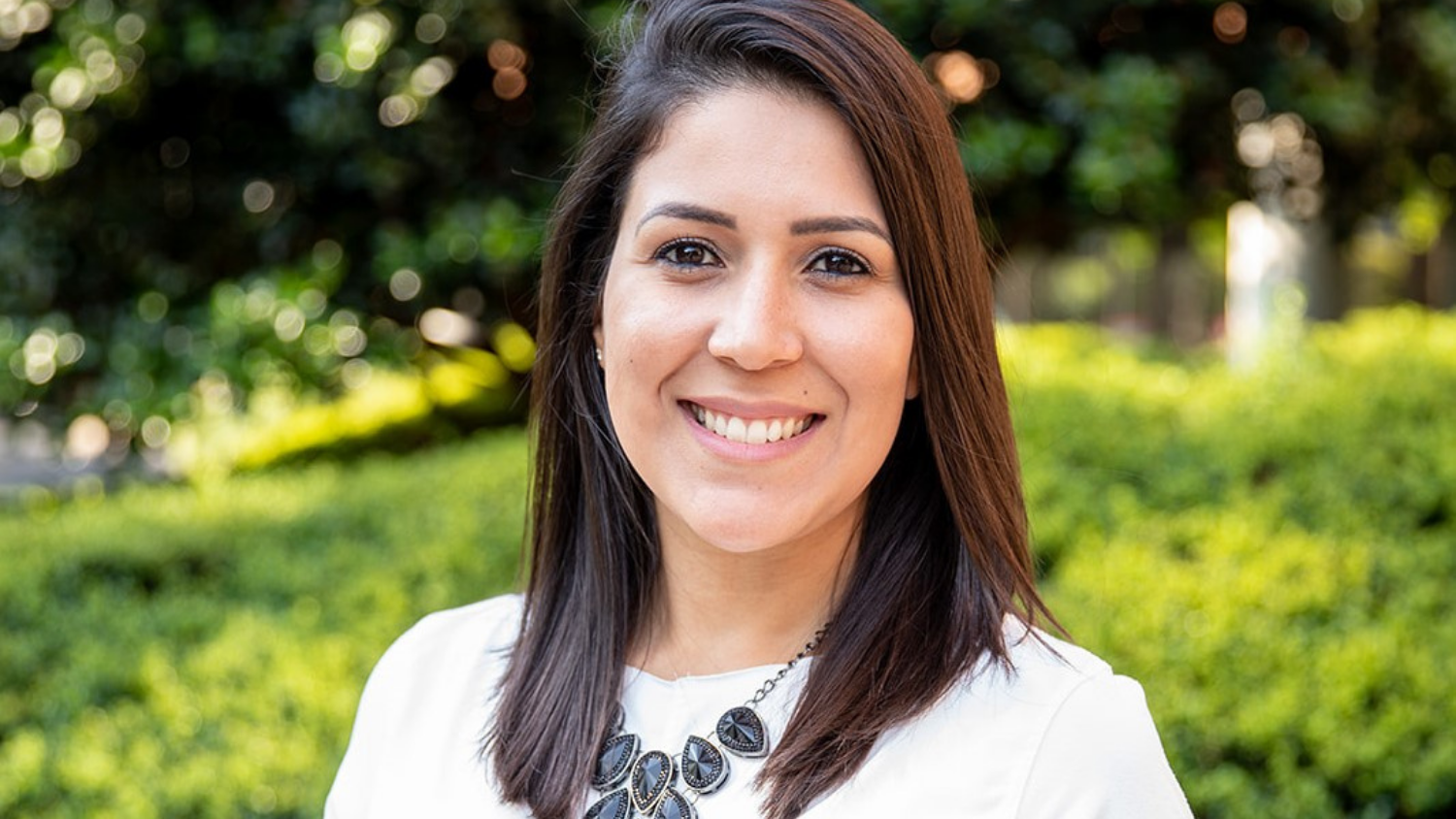 Woman smiling in non-tradional outside headshot