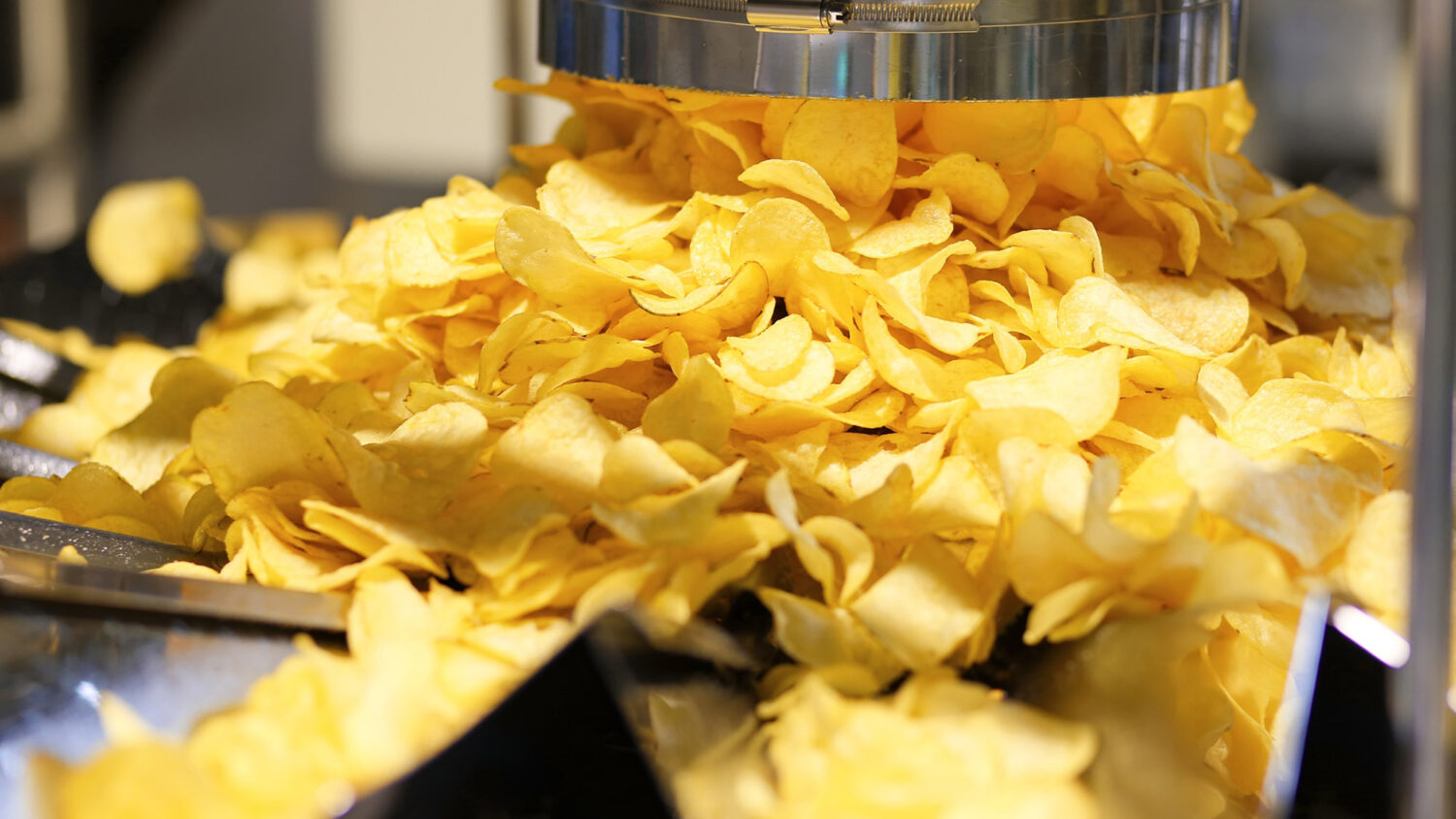 Potato chips production line at the plant. Filling machines for potato chips and snacks.