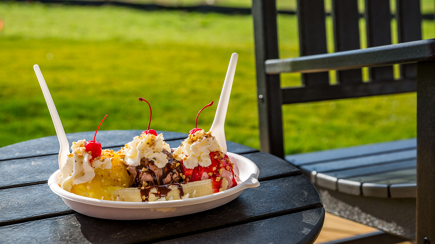 A banana split sundae with cherries and whipped cream