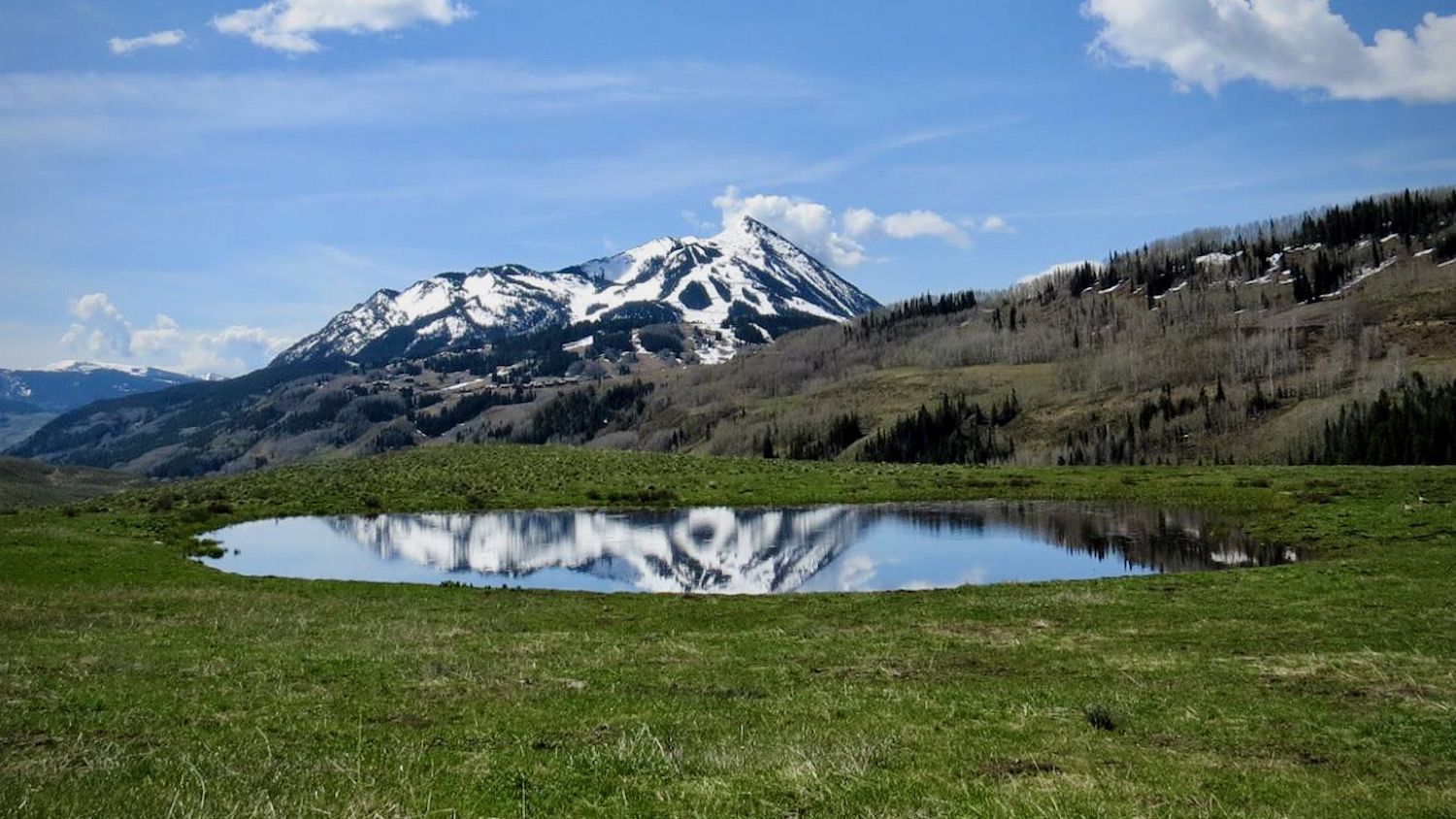 A photo of an alpine pond with a mountain in its reflection by Susan Washko