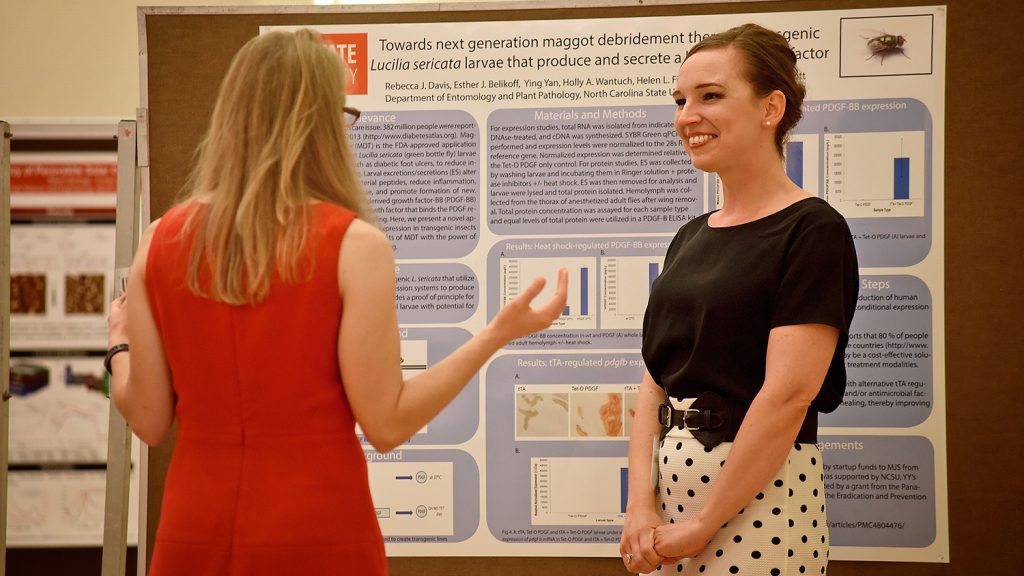 A student presenting a poster at a research symposium
