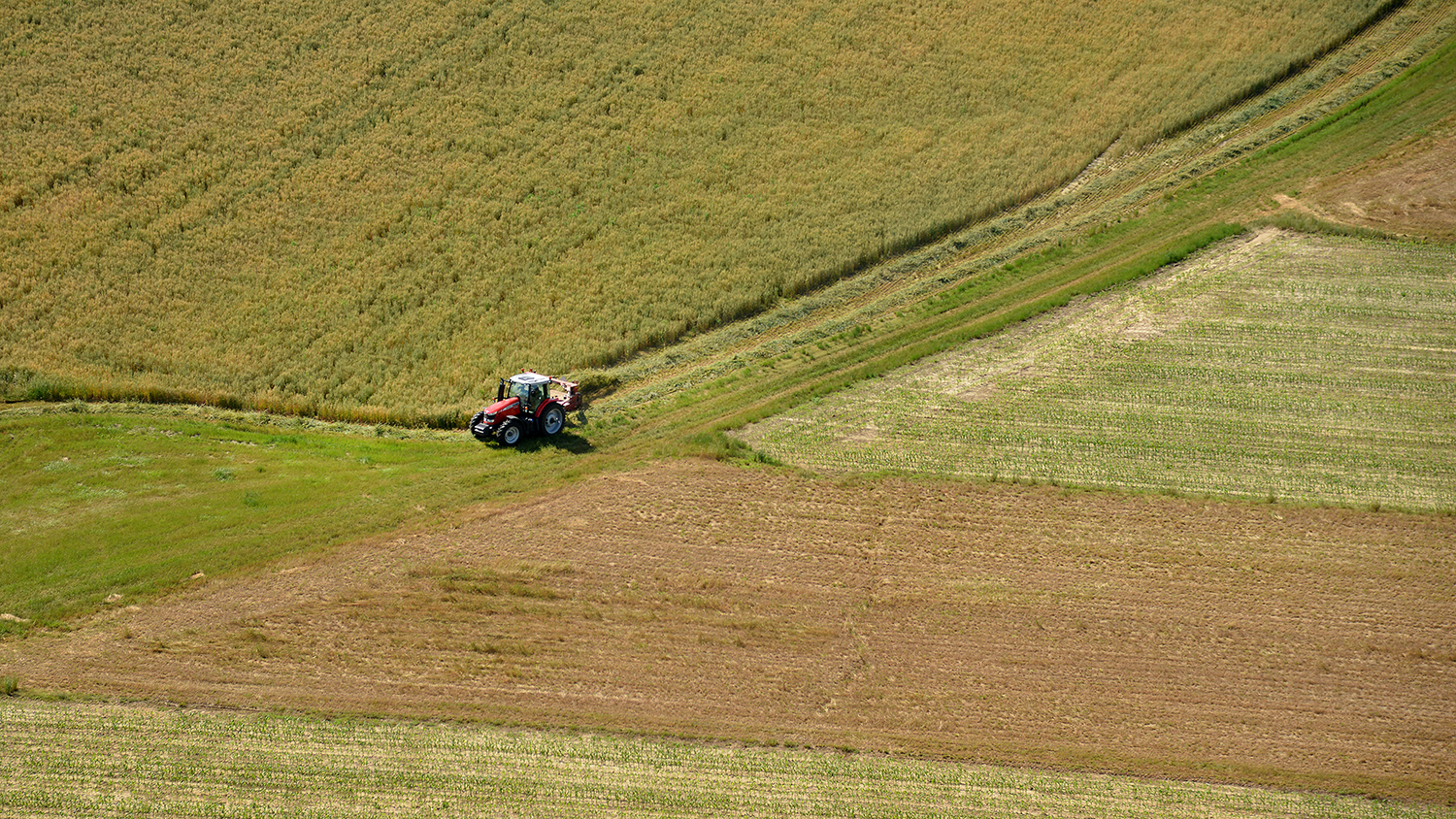an aerial shot of a tractor in a large field