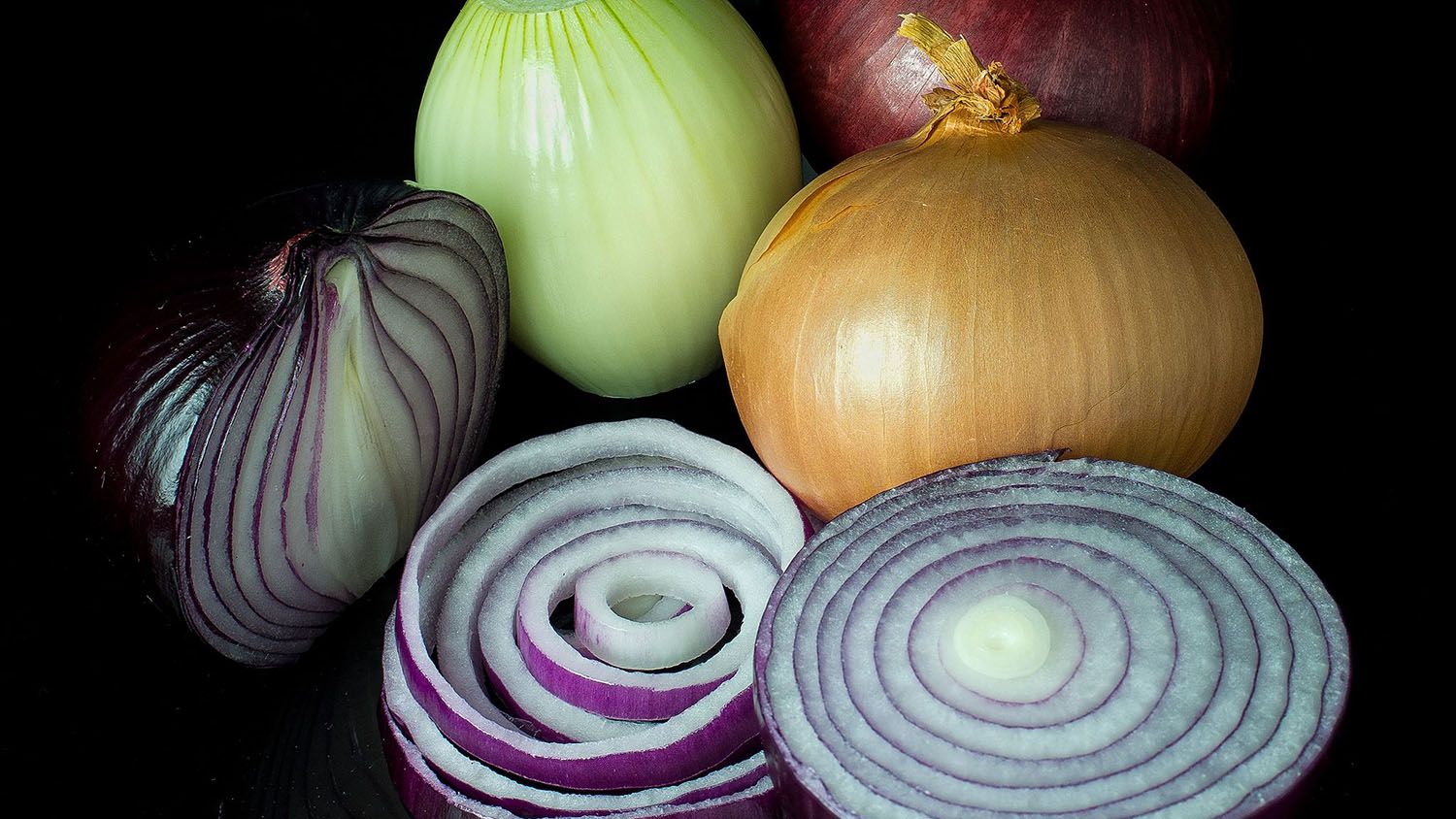 a bunch of red, white and yellow onions on a table