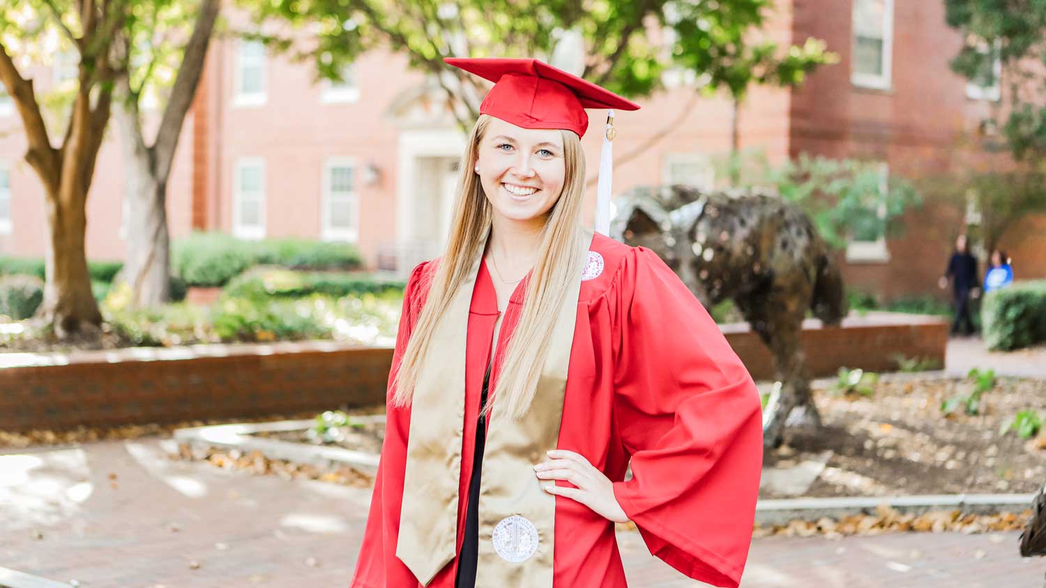 Sophie Chance in her cap and gown on NC State's campus