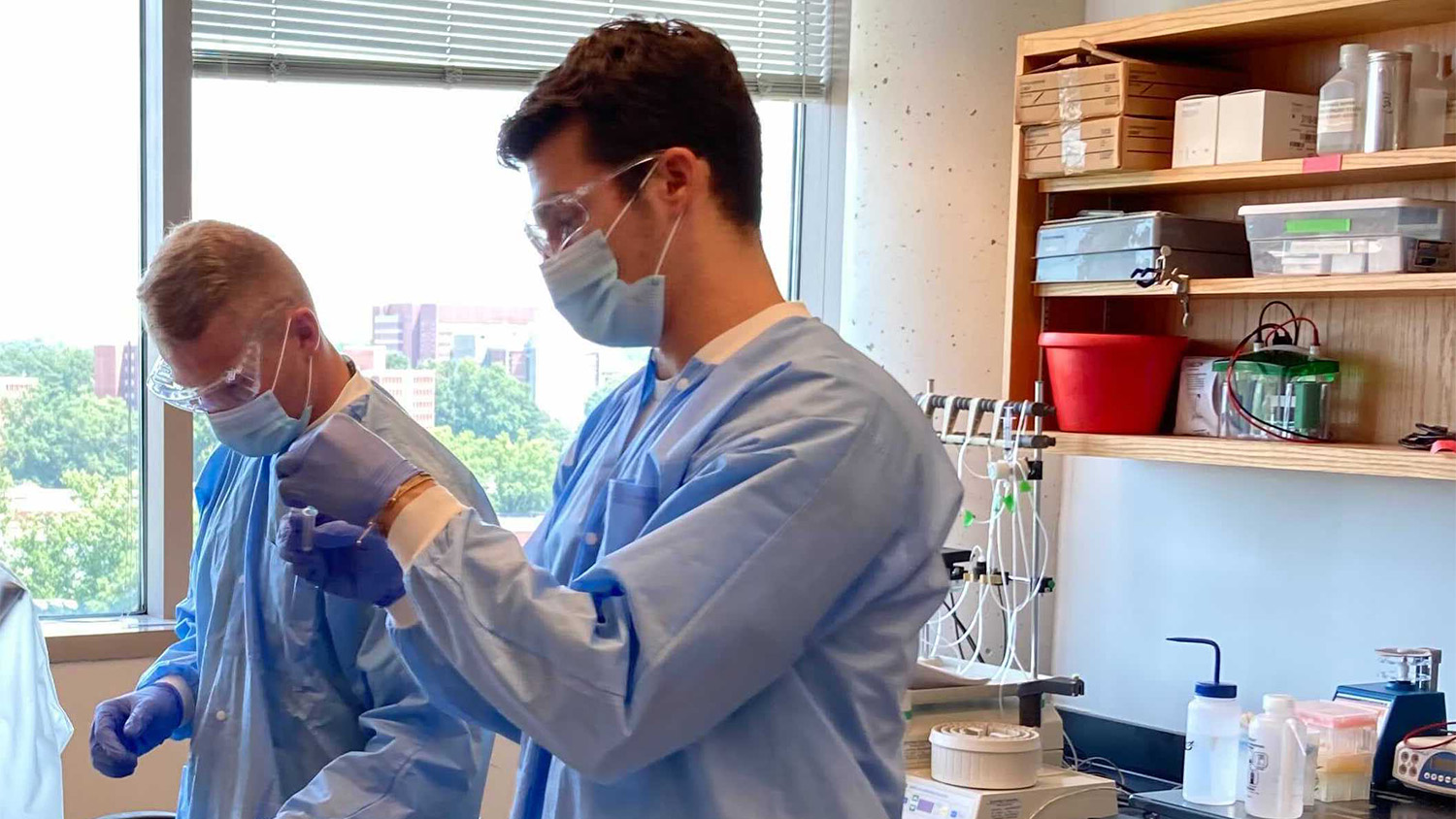 A young man wearing protective lab gear in a lab