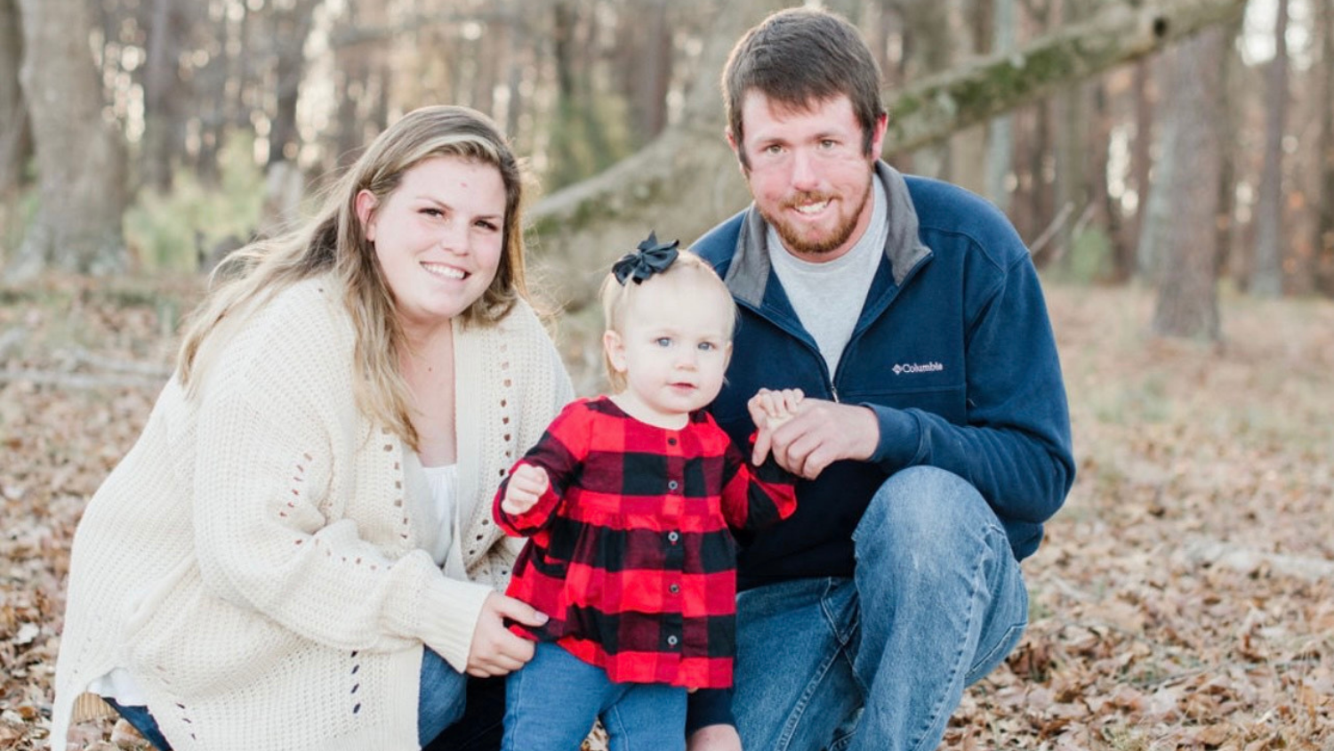 a woman, man, and their baby daughter smiling