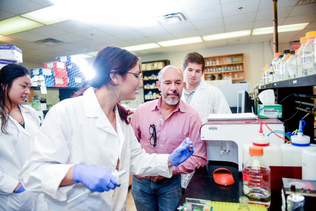 Dr. Trino watches as his students complete lab work.