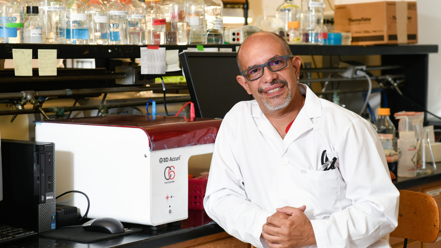 a man in a research lab smiling