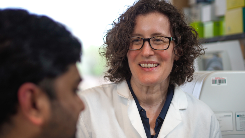 two researchers in a lab smiling