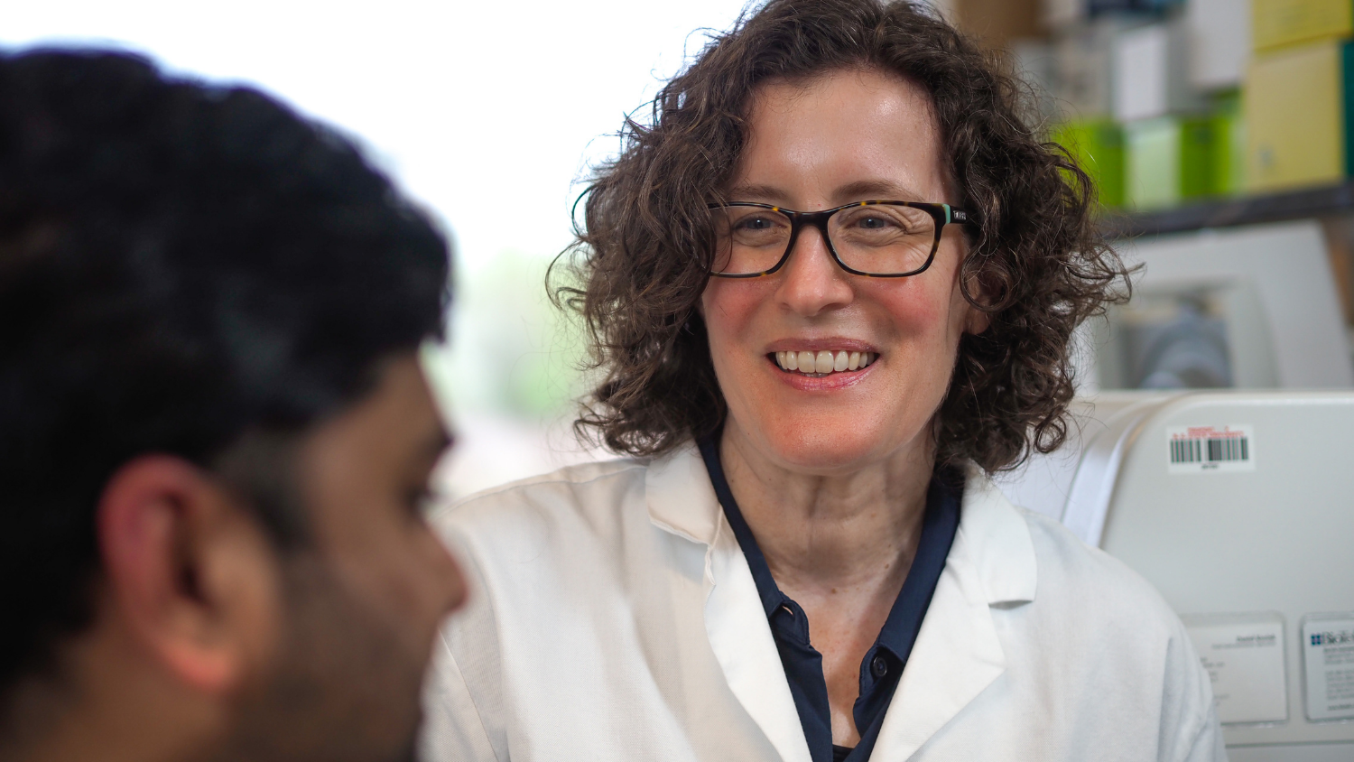 a female researcher in a lab smiling
