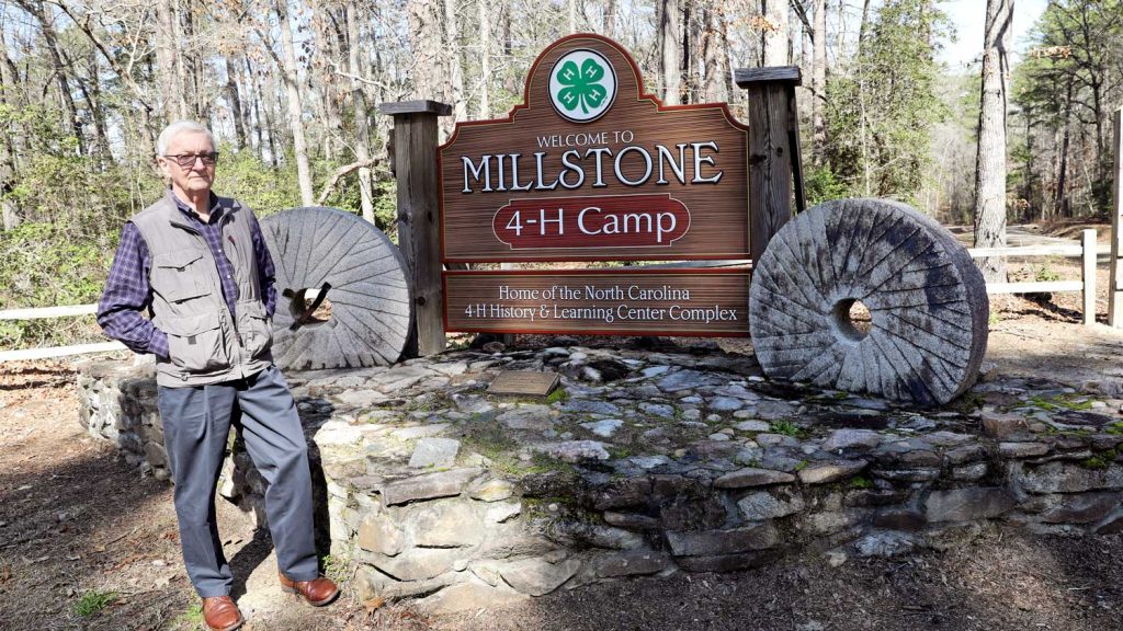 An older man standing next to the Millstone 4-H sign