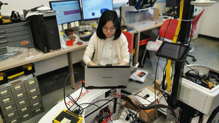 a woman working with robotics in a lab