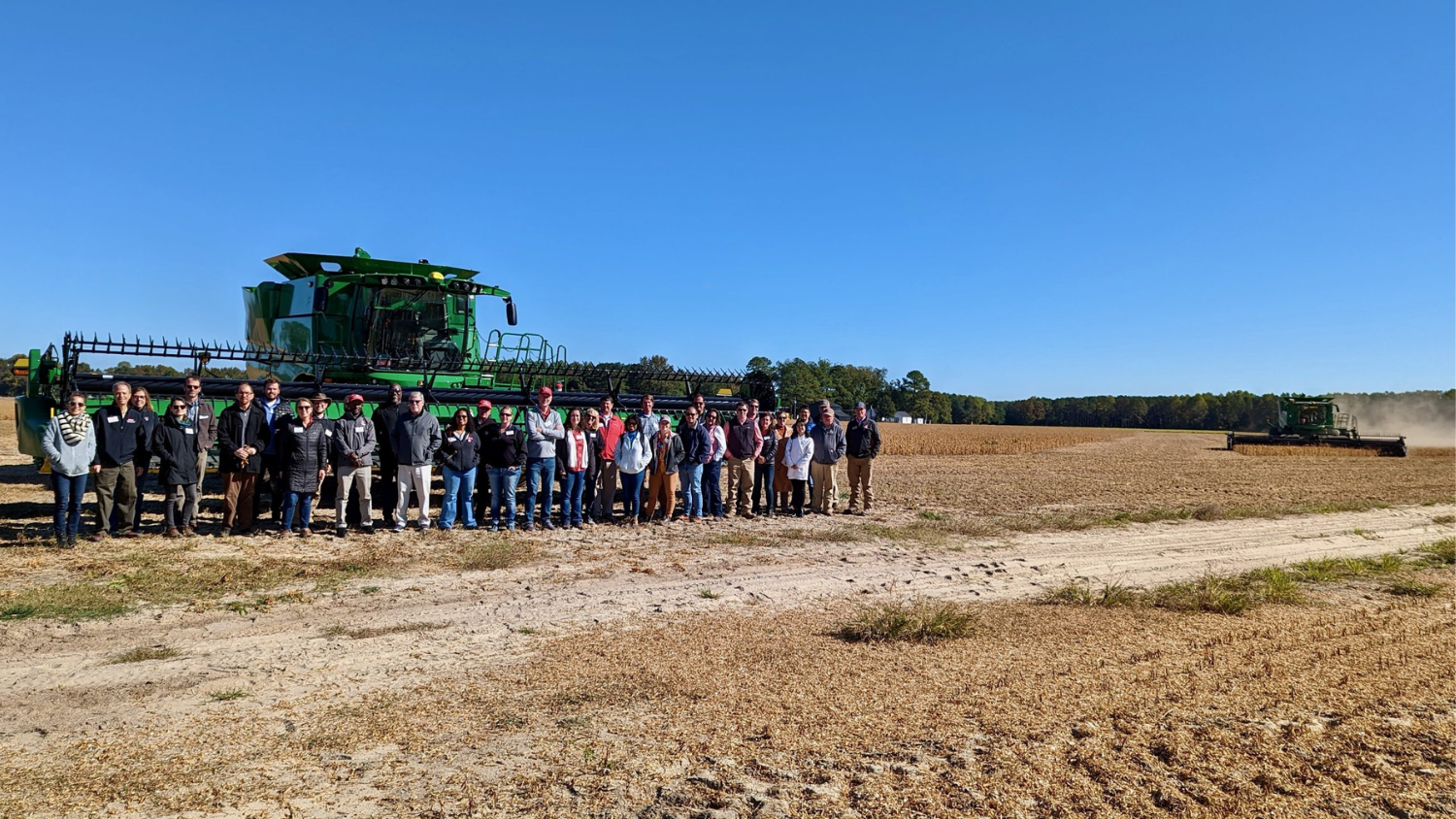 N.C. PSI faculty in a field in front of a large machine