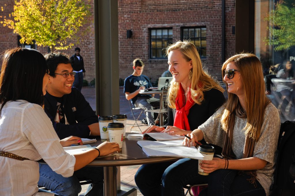 students talking at a table outside