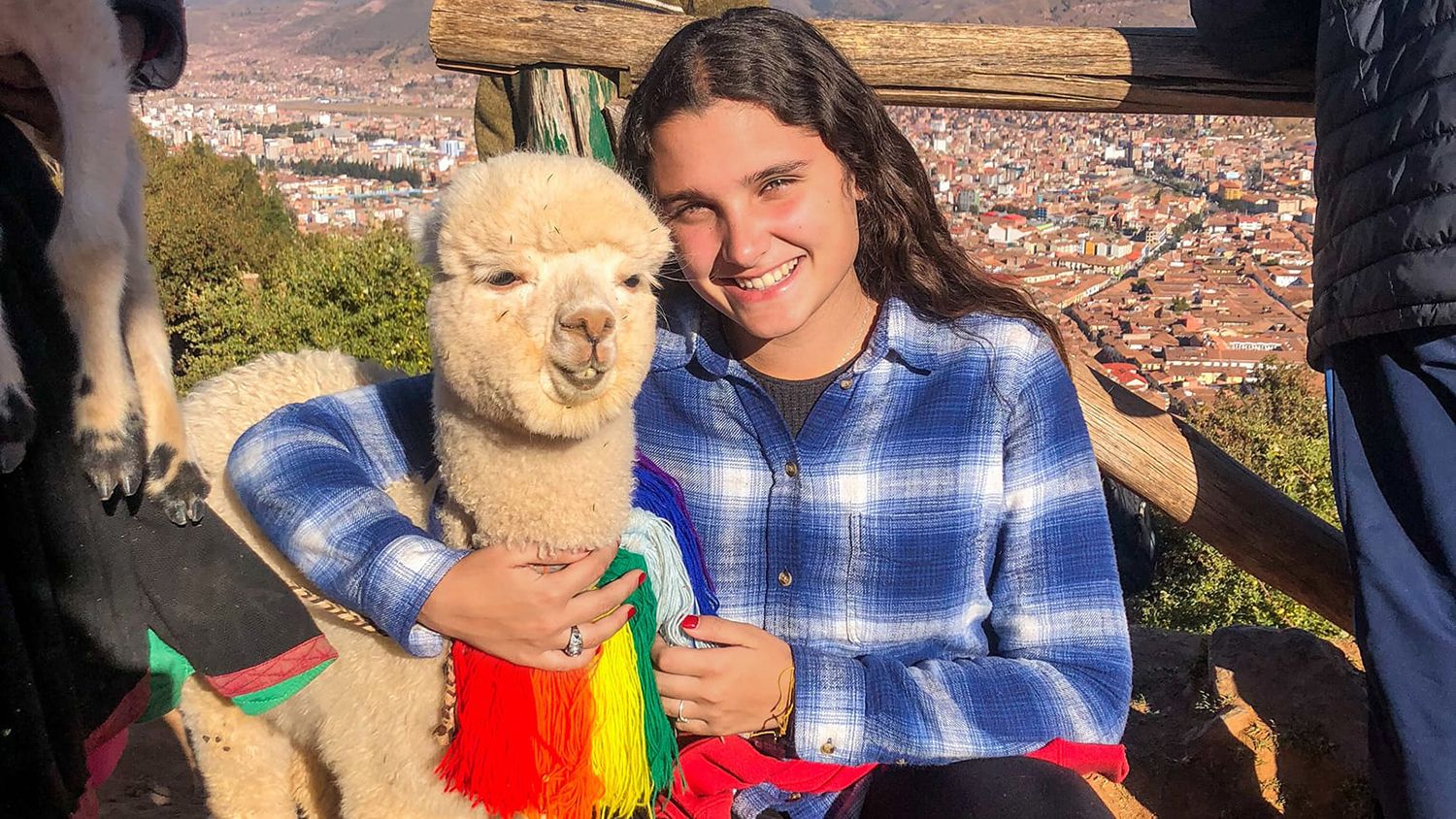 Female student hugging an alpaca