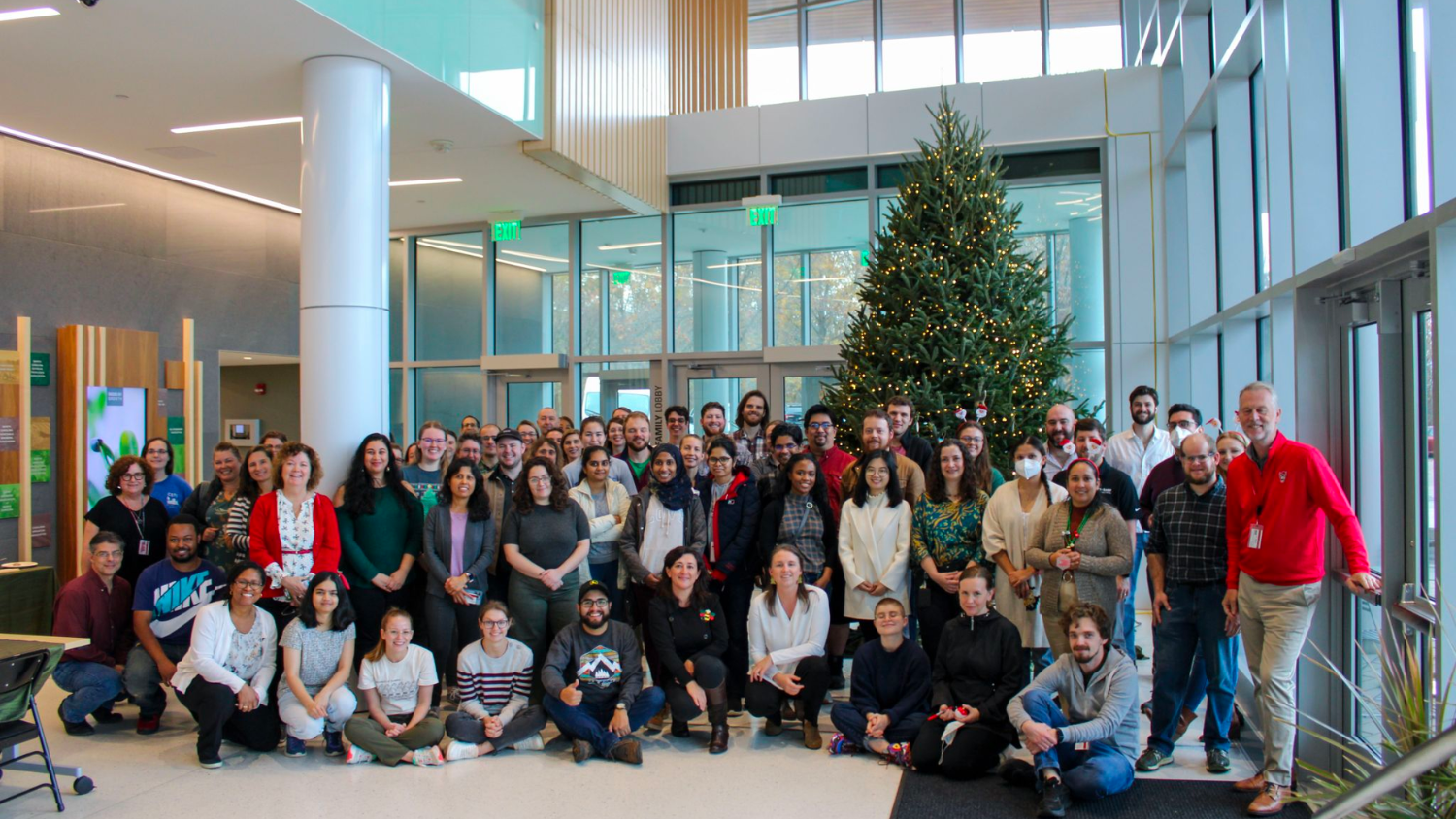 a group photo in front of the N.C. PSI holiday tree