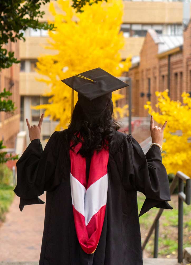 The back of a young woman wearing graduation regalia