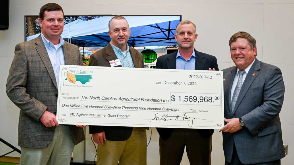 Four men holding a large check