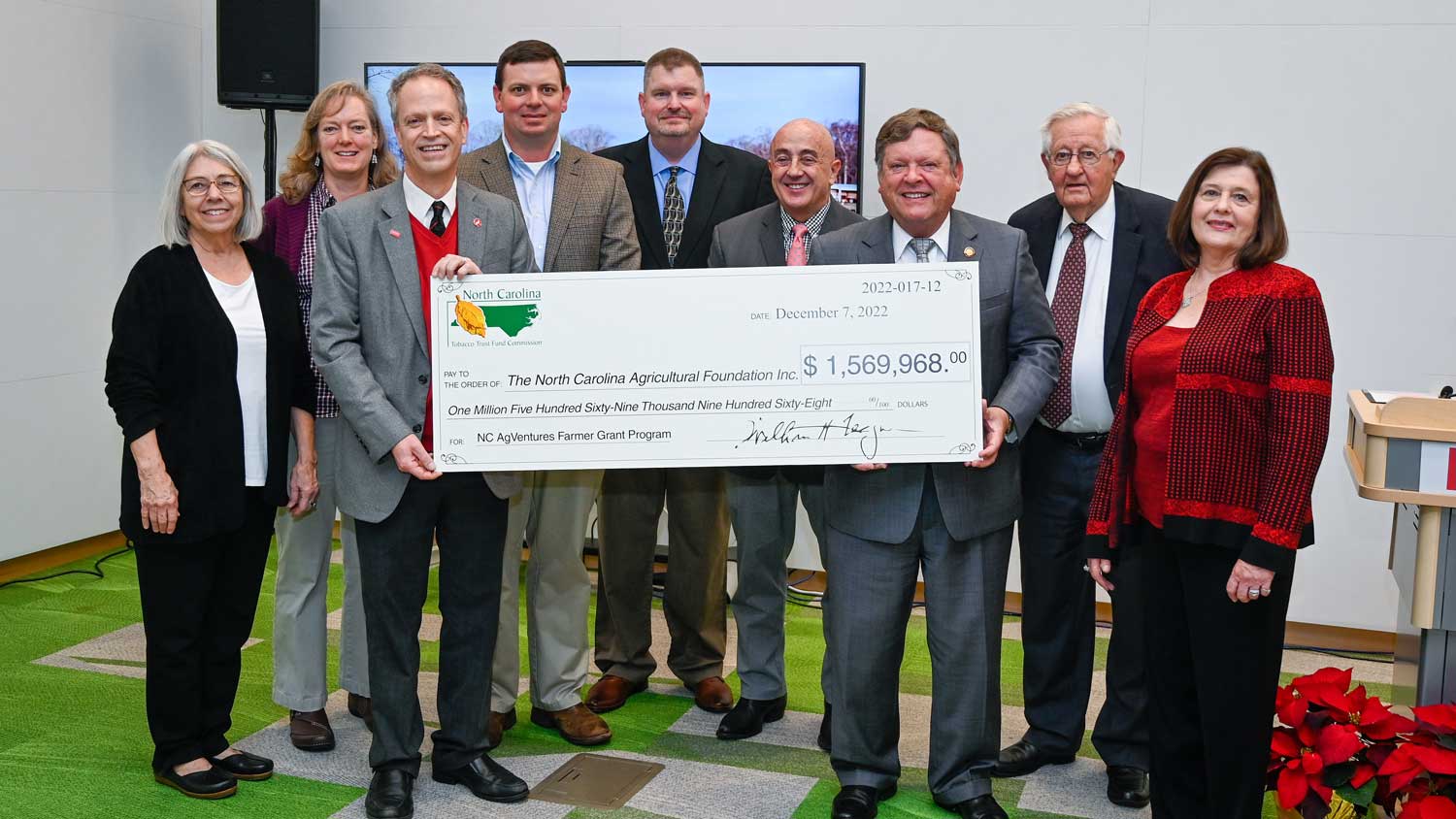 A group of people holding a large check