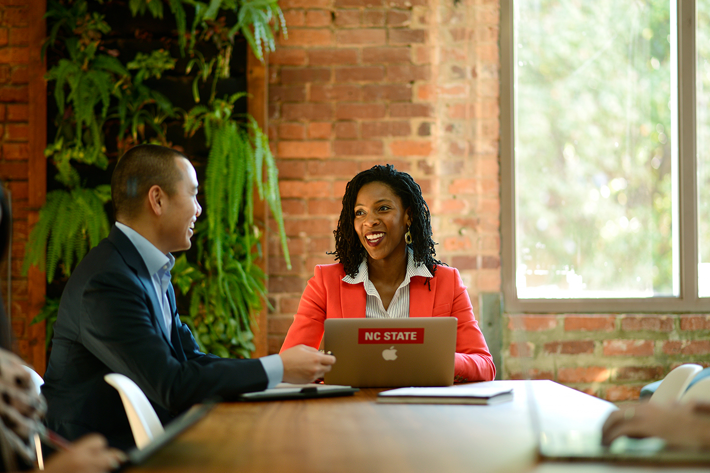 A man and woman in business suits sitting at a table talking