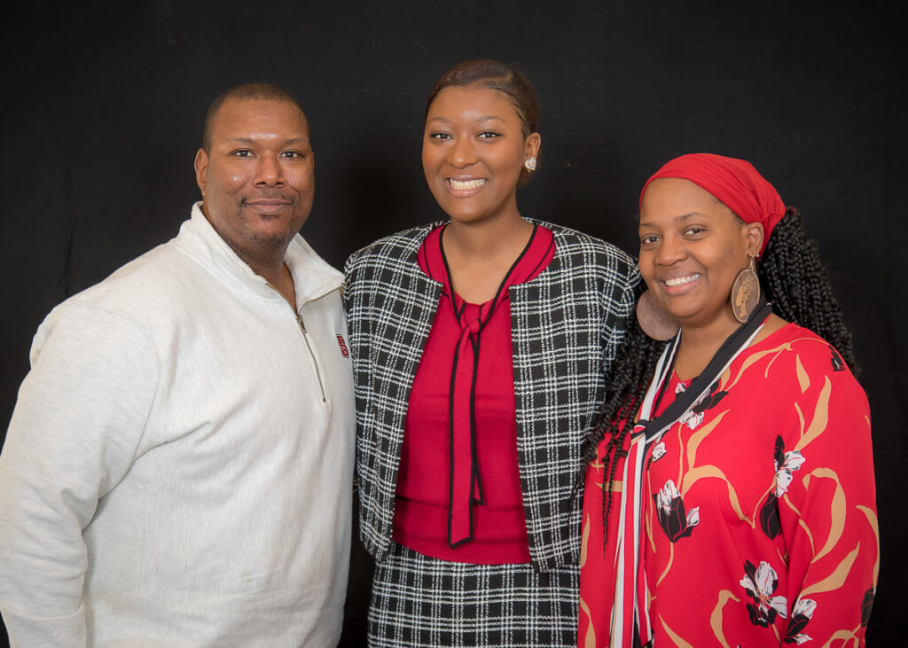 Young woman posing with her parents.