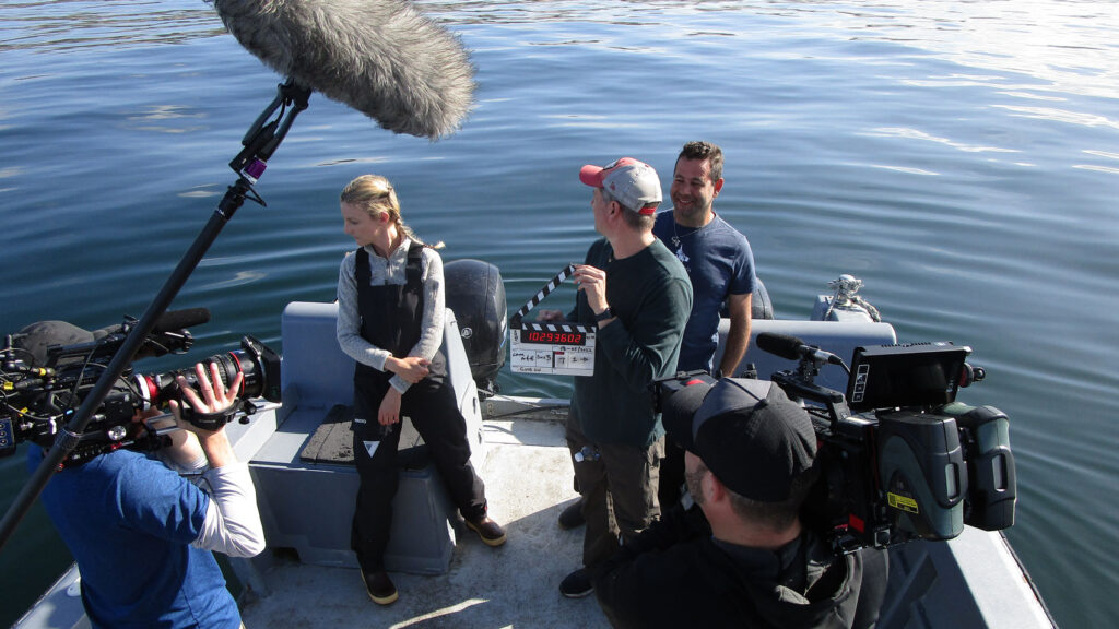 Woman and film crew on a boat