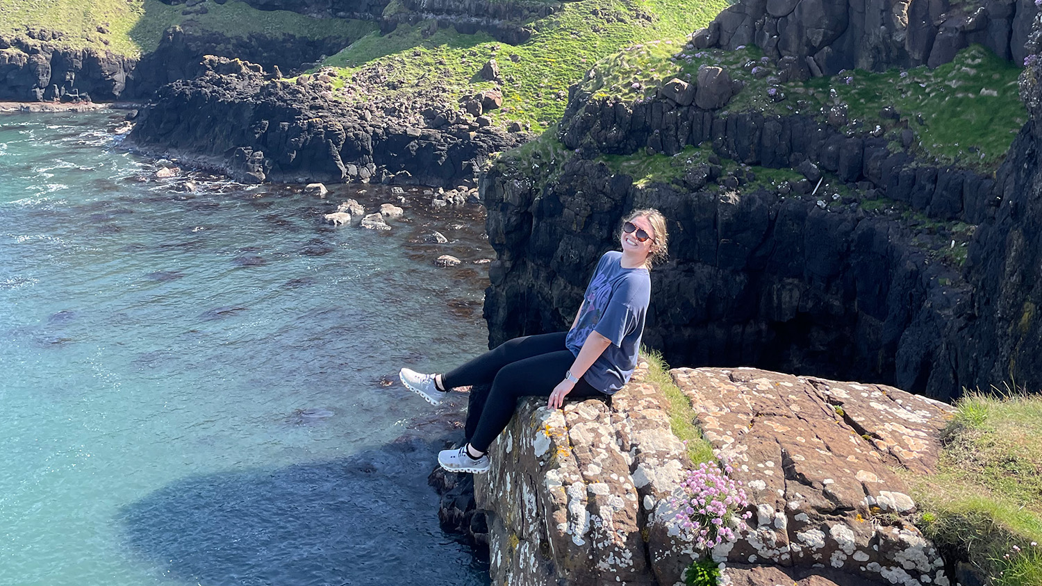 Female student sitting on rocky Irish coast