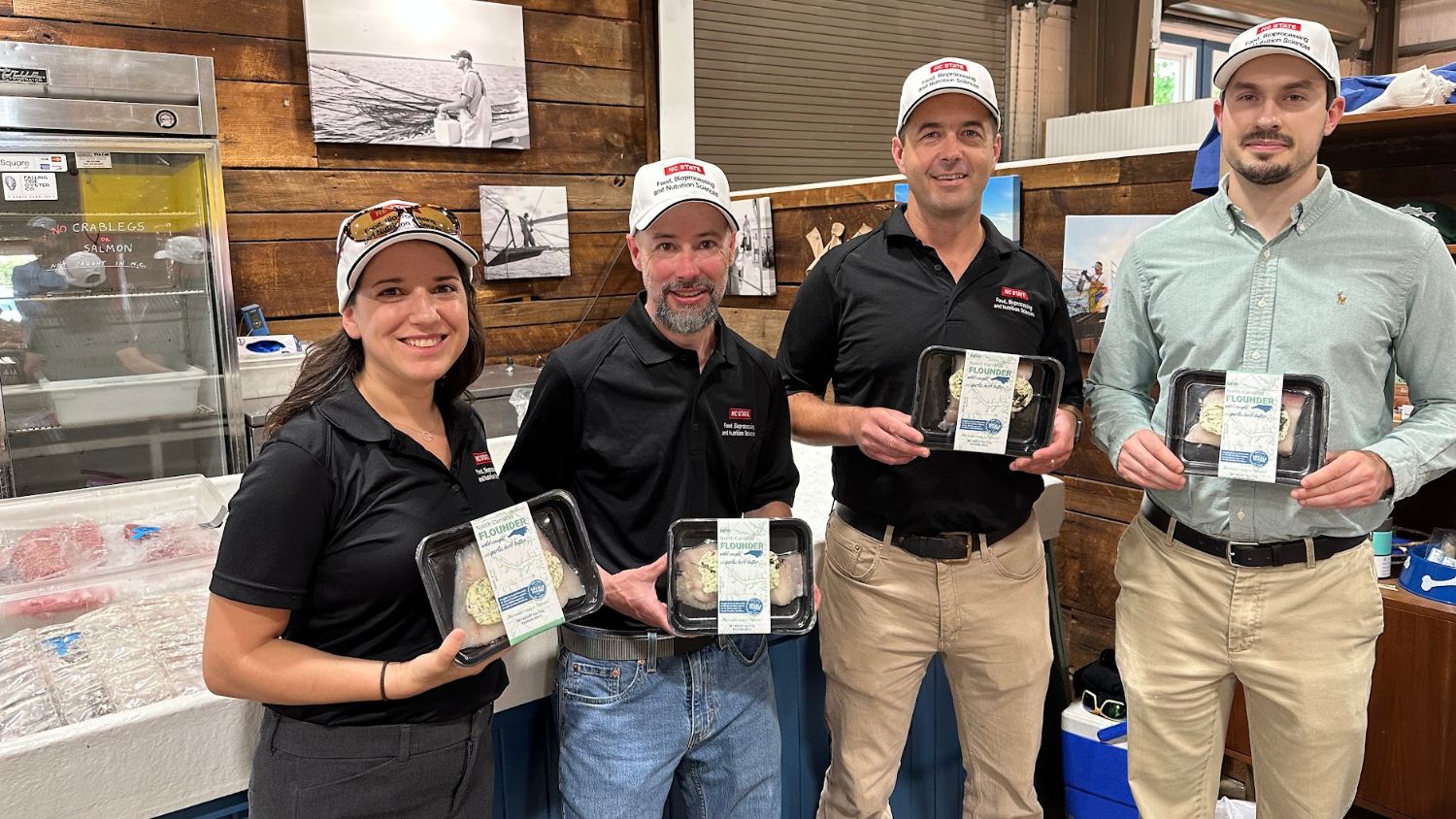 Four FBNS faculty and staff holding a new seafood product