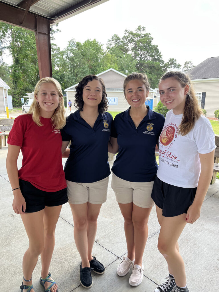 Four young women posing outside