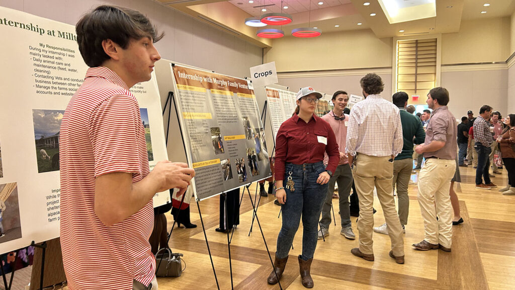 students in a ballroom with poster presentations