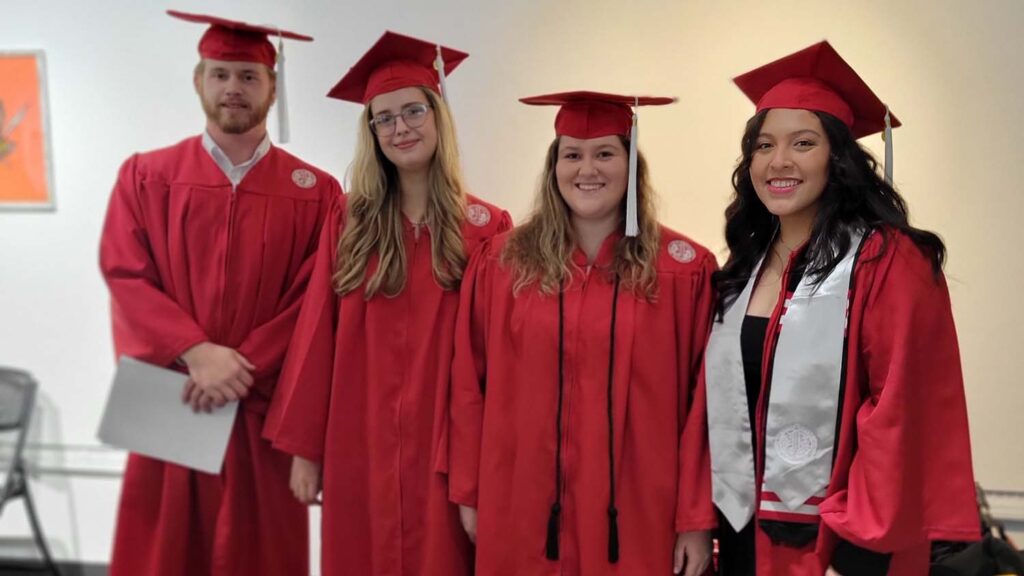 college graduates wearing red caps and gowns