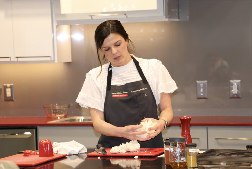 a woman cuts food in a kitchen