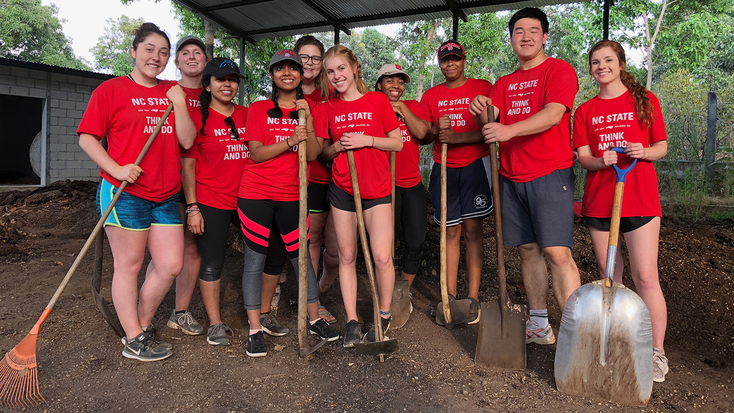 Students with garden tools and wearing red t-shirts