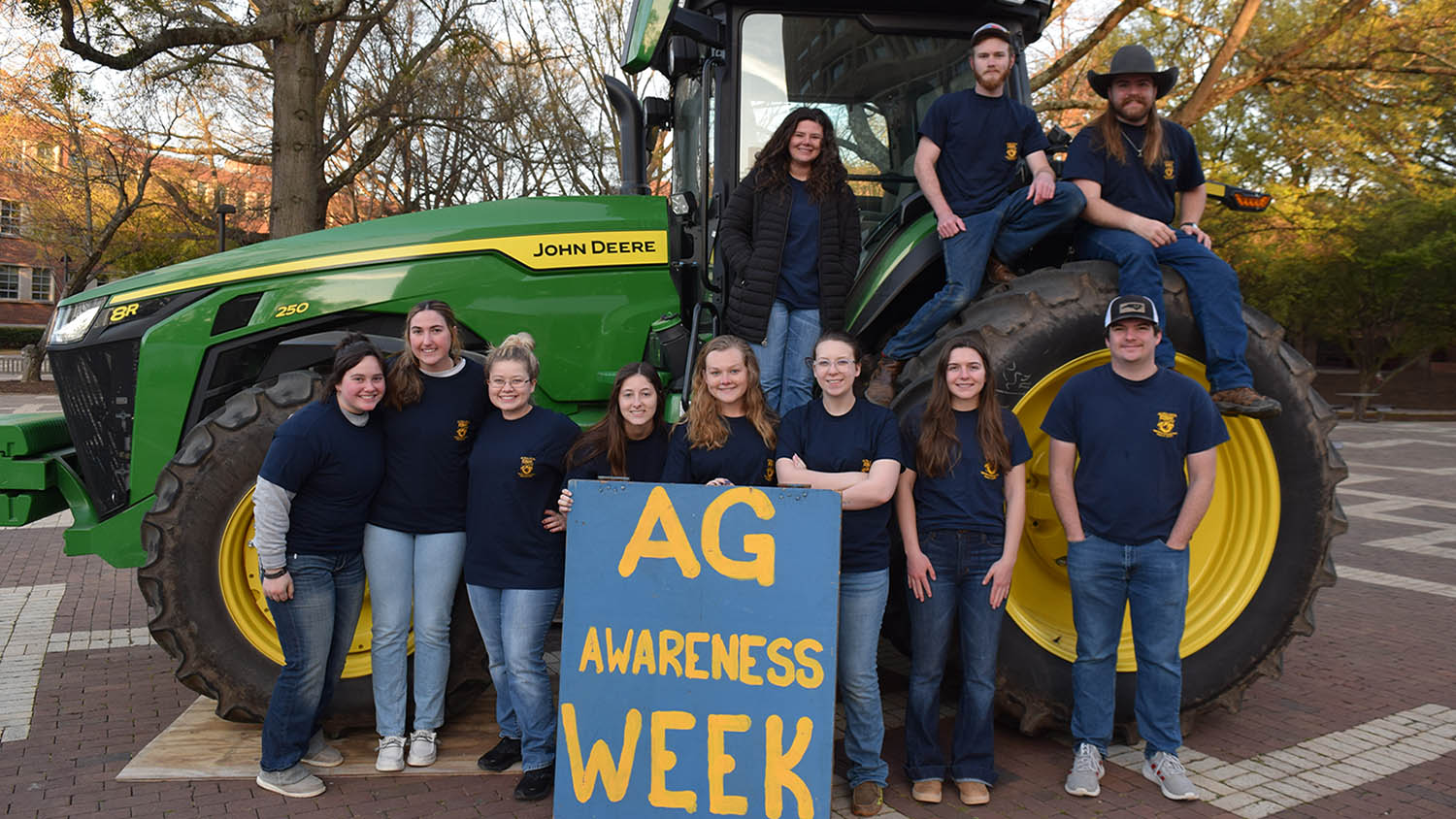 people in front of a tractor with a sign that reads ag awareness week