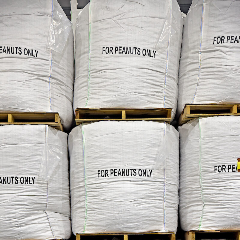 peanuts packed in large white labeled bags.