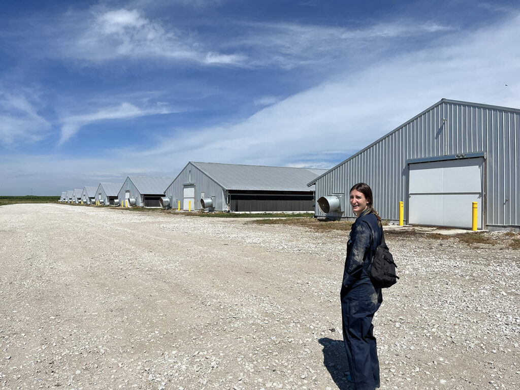 a woman in dark clothes outside a silver industrial building