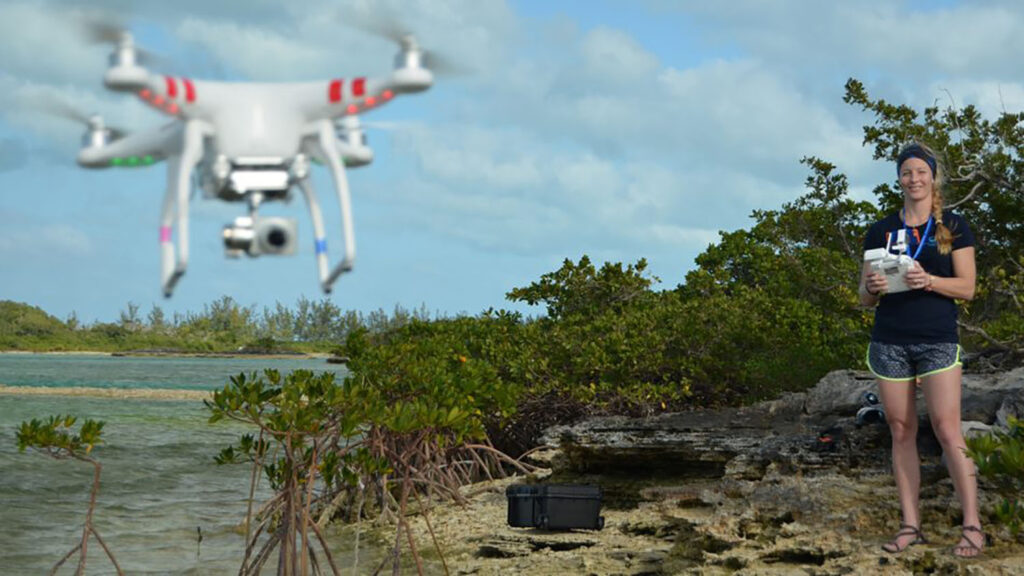 An applied ecology student uses a drone to survey a shoreline.