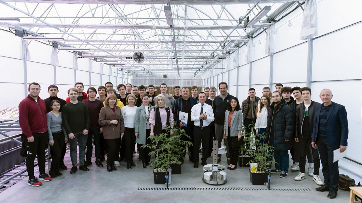 a group of people stand in a high-tech greenhouse