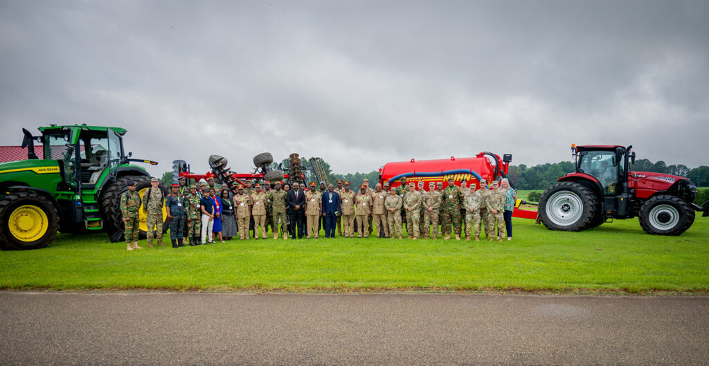 a large group of people stand in front of tractors