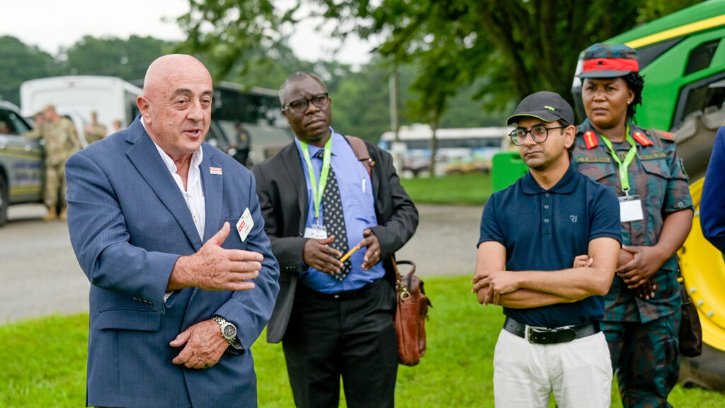 several people speak outside in a farm setting